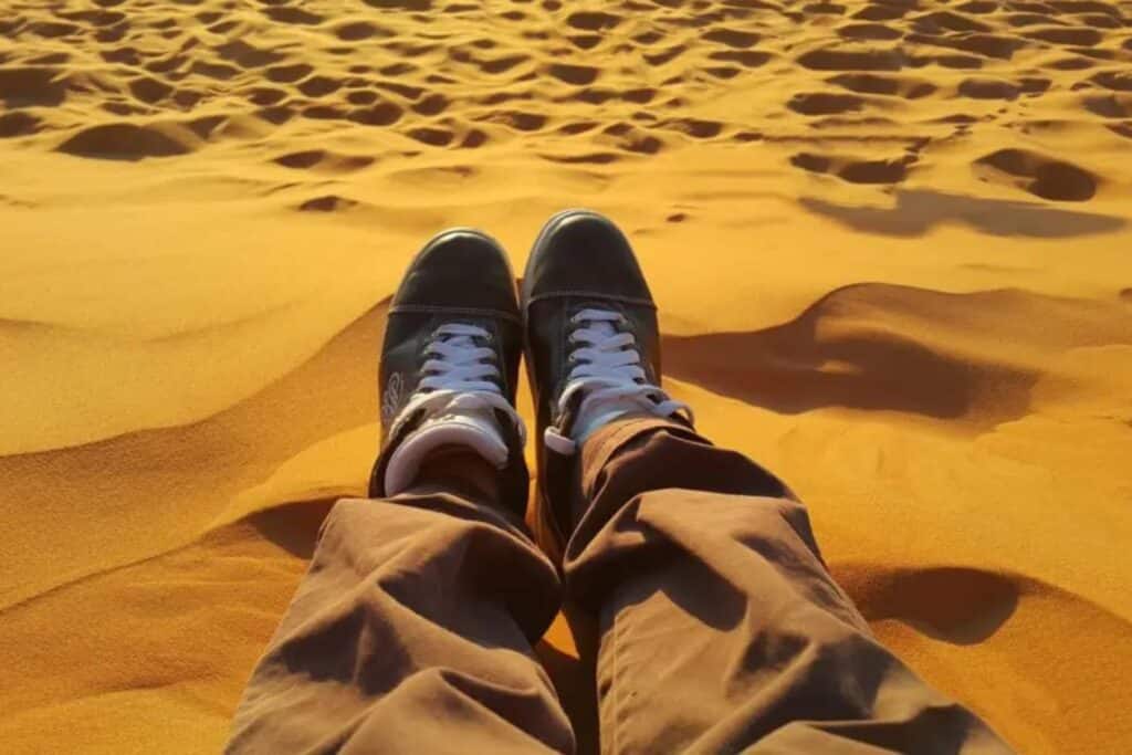 chaussure d´un touriste dans le désert du sahara