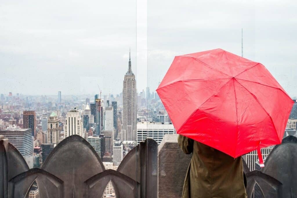 Voyageur avec un parapluie rouge regardant la vue à New York