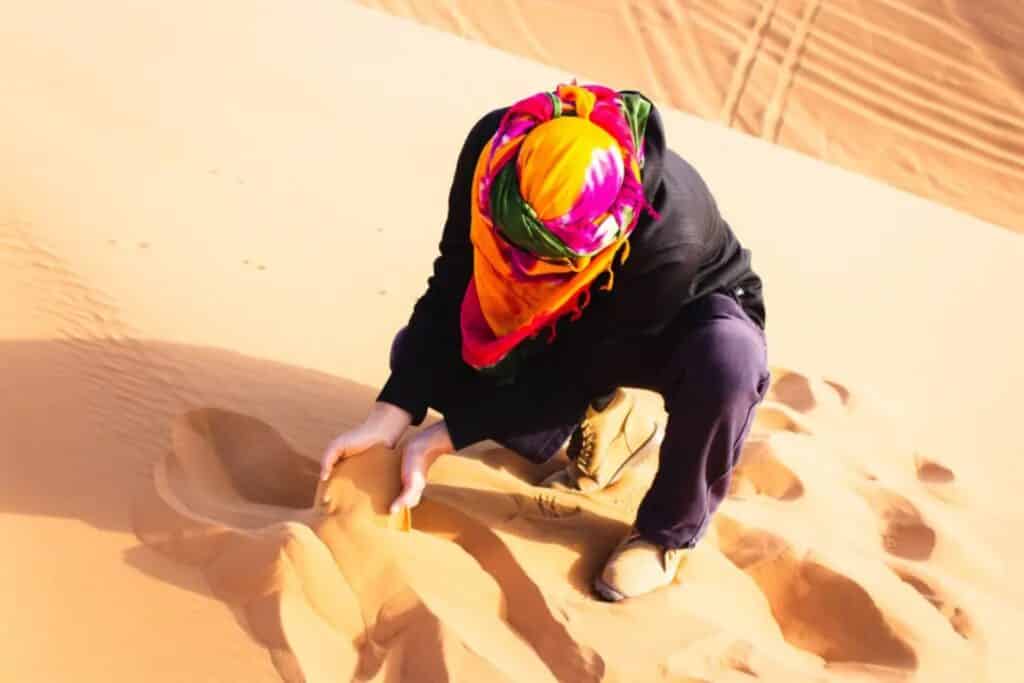 Touriste touchant le sable fin du maroc 